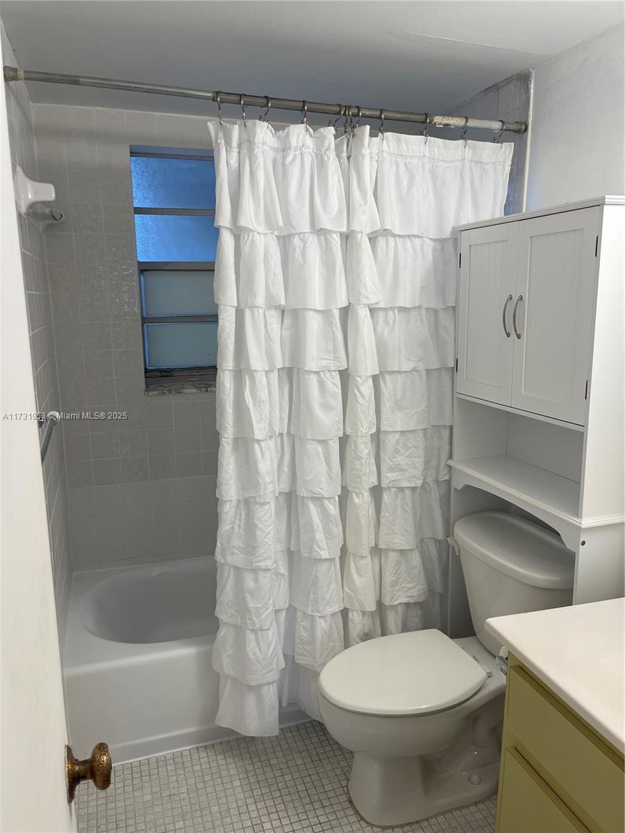 7787 Southwest 86th Street, Unit E211 Miami, FL 33143 - Photo 17 of 27 a bathroom with a toilet and a shower