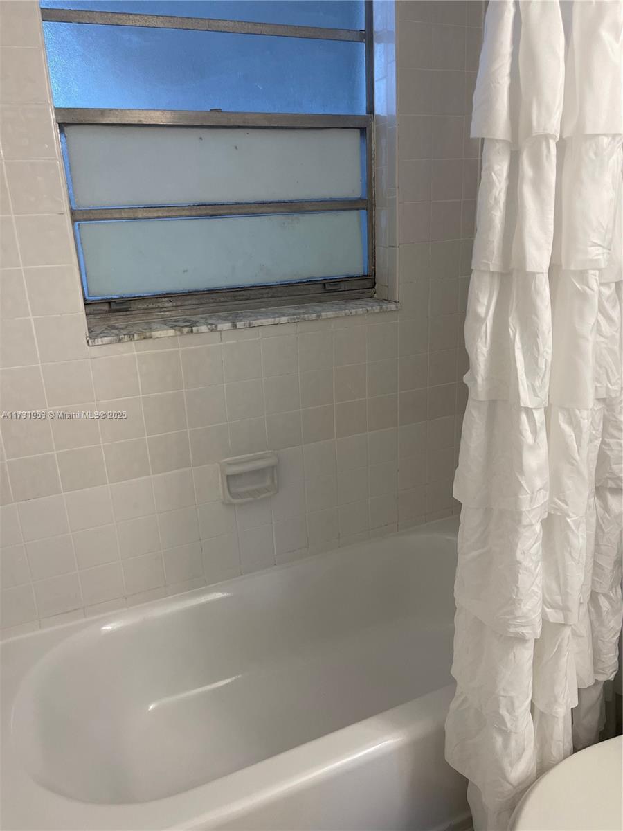 7787 Southwest 86th Street, Unit E211 Miami, FL 33143 - Photo 18 of 27 a bathroom with a bathtub