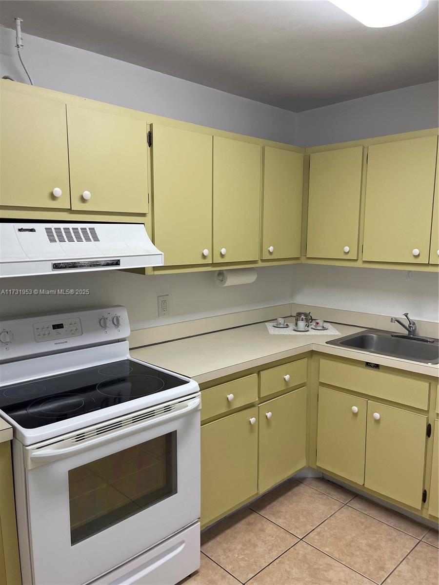 7787 Southwest 86th Street, Unit E211 Miami, FL 33143 - Photo 2 of 27 a kitchen with a sink and cabinets