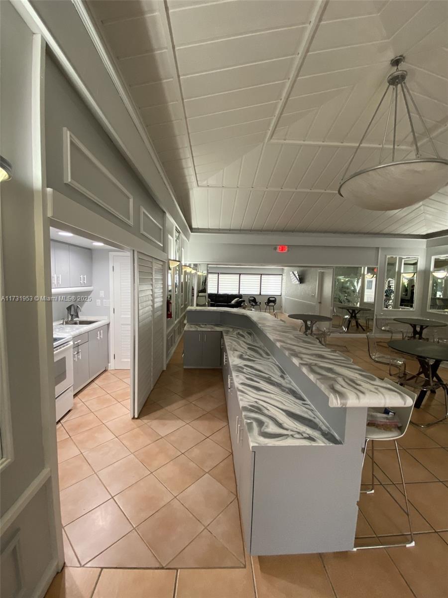 7787 Southwest 86th Street, Unit E211 Miami, FL 33143 - Photo 22 of 27 a kitchen with stainless steel appliances granite countertop a sink and a refrigerator