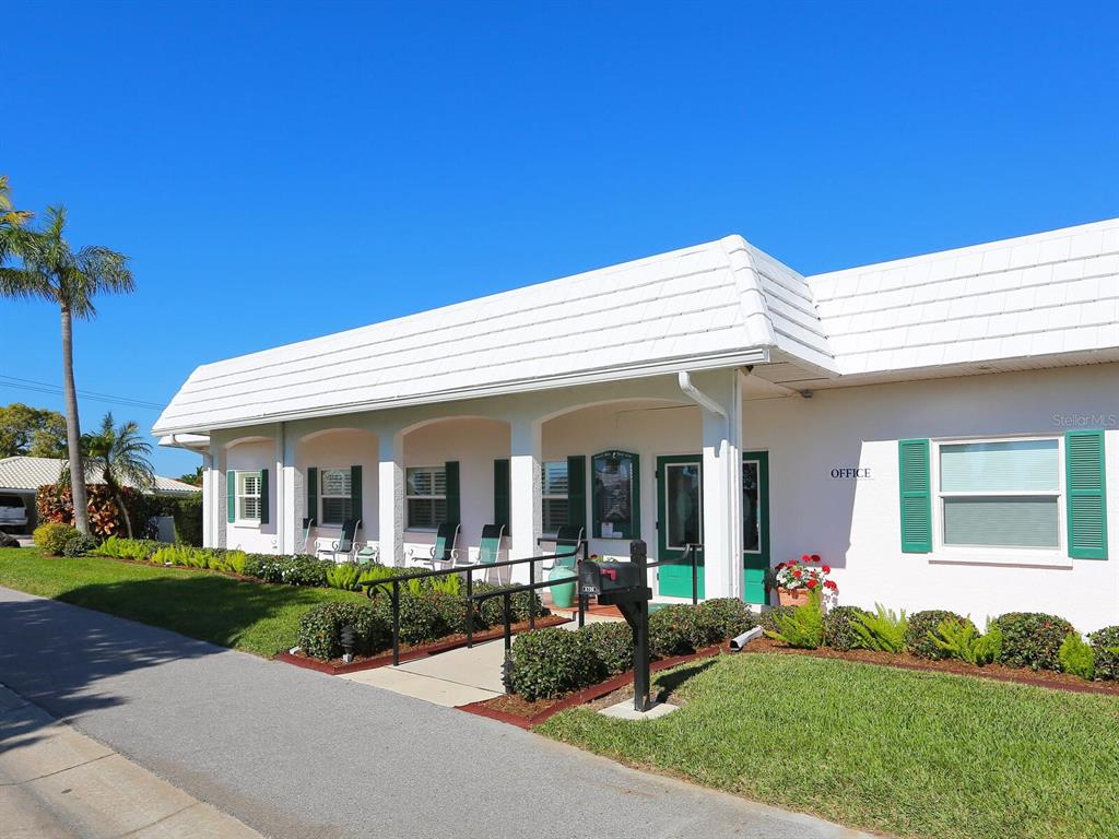 667 El Centro Longboat Key, FL 34228 - Photo 21 of 41 a view of a white house with a big yard and potted plants