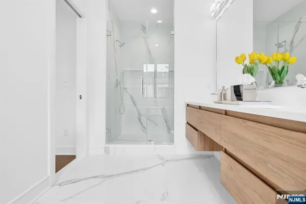 a bathroom with a sink a mirror and a shower
