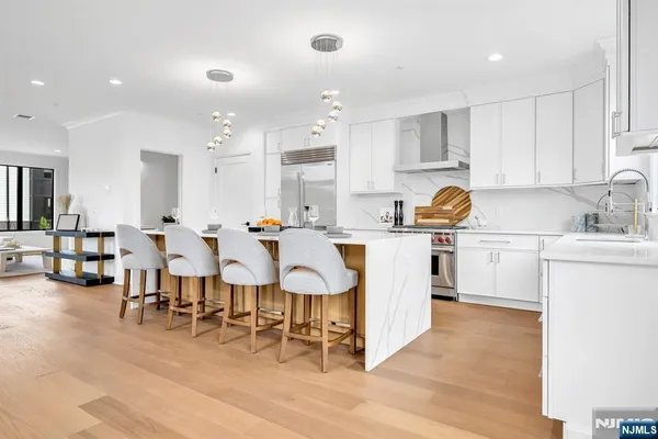 a kitchen with white cabinets and chairs