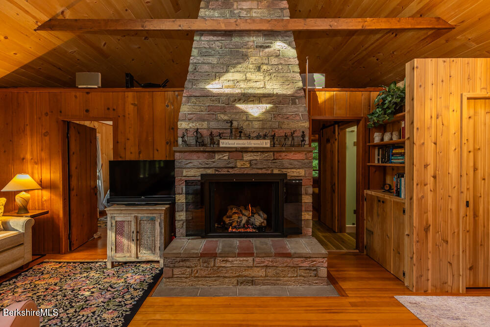 3 Indian Road Stockbridge, MA 01262 - Photo 5 of 23 a living room with a fireplace and a table