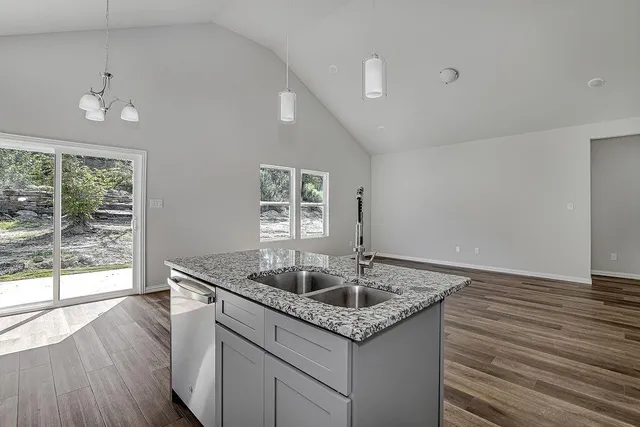 a kitchen with stainless steel appliances granite countertop a stove a sink and a microwave