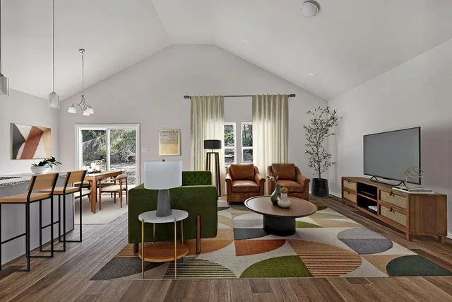 a living room with furniture a flat screen tv and a table