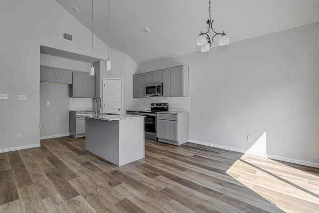 a kitchen with stainless steel appliances granite countertop a sink and cabinets
