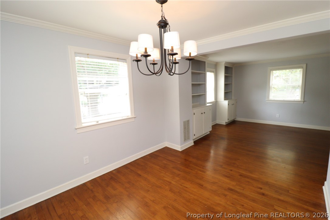 1000 Nichols Drive Raleigh, NC 27605 - Photo 7 of 22 an empty room with wooden floor fan and windows