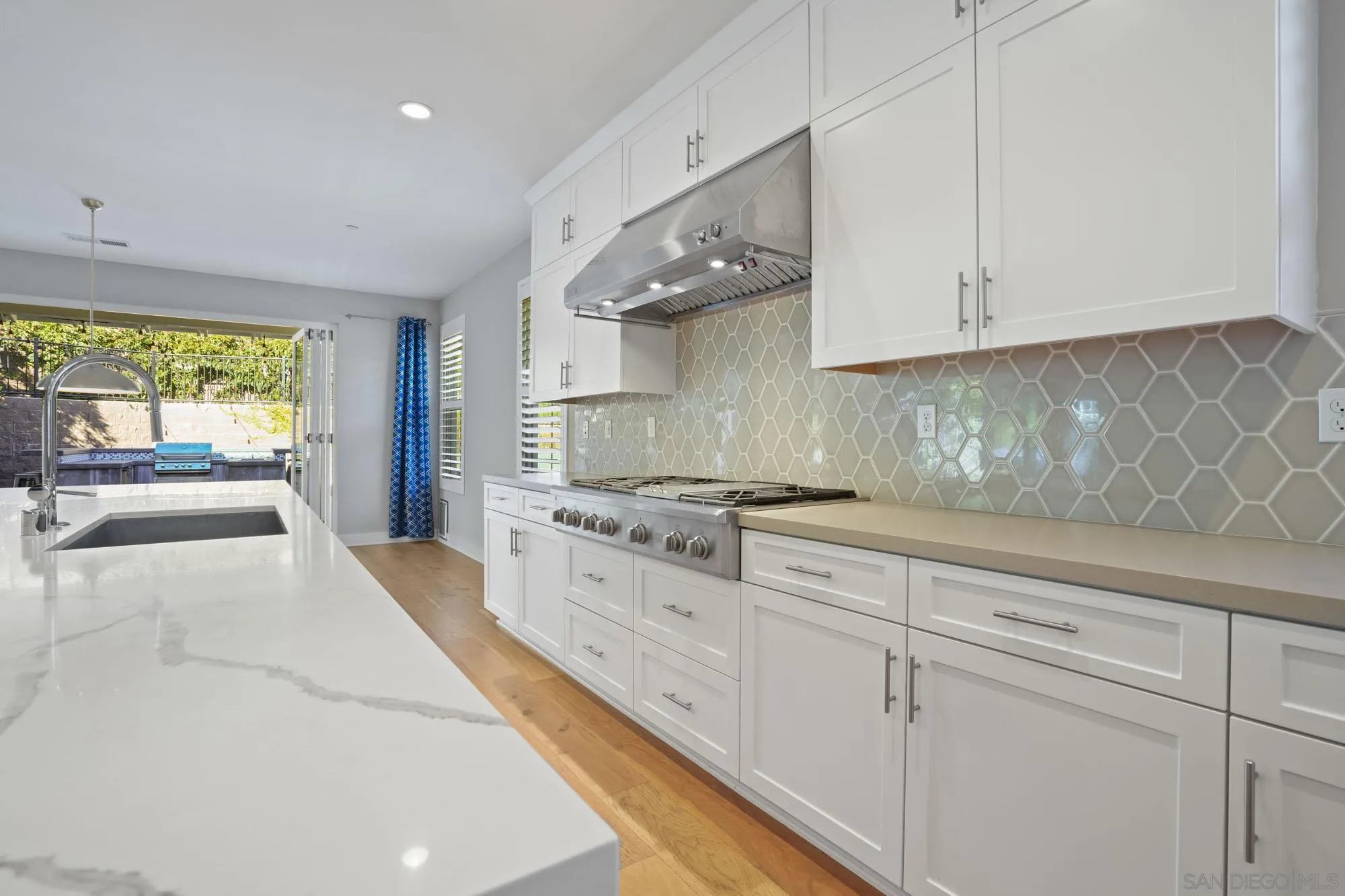 833 Channel Island Drive Encinitas, CA 92024 - Photo 12 of 38 a large white kitchen with granite countertop a stove a sink and white cabinets