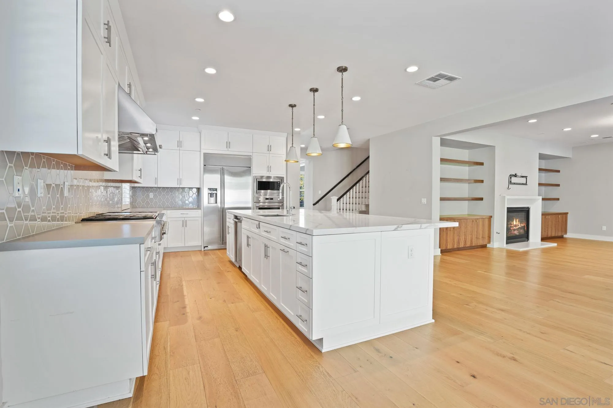 833 Channel Island Drive Encinitas, CA 92024 - Photo 10 of 38 a large white kitchen with wooden floors and stainless steel appliances