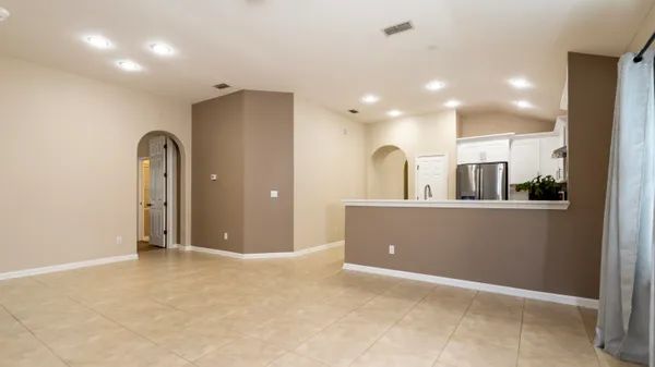 a view of a livingroom with a chandelier fan and windows