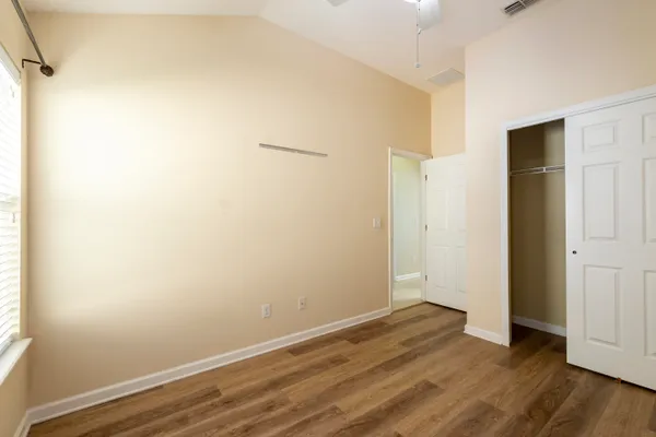 an empty room with wooden floor and windows