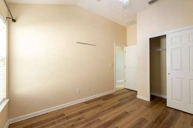 an empty room with wooden floor and windows