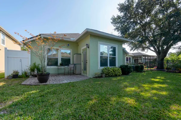 a view of a backyard with table and chairs potted plants and tree