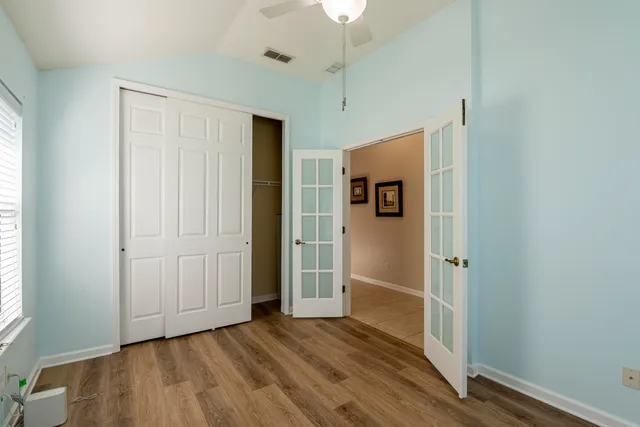 an empty room with wooden floor and windows
