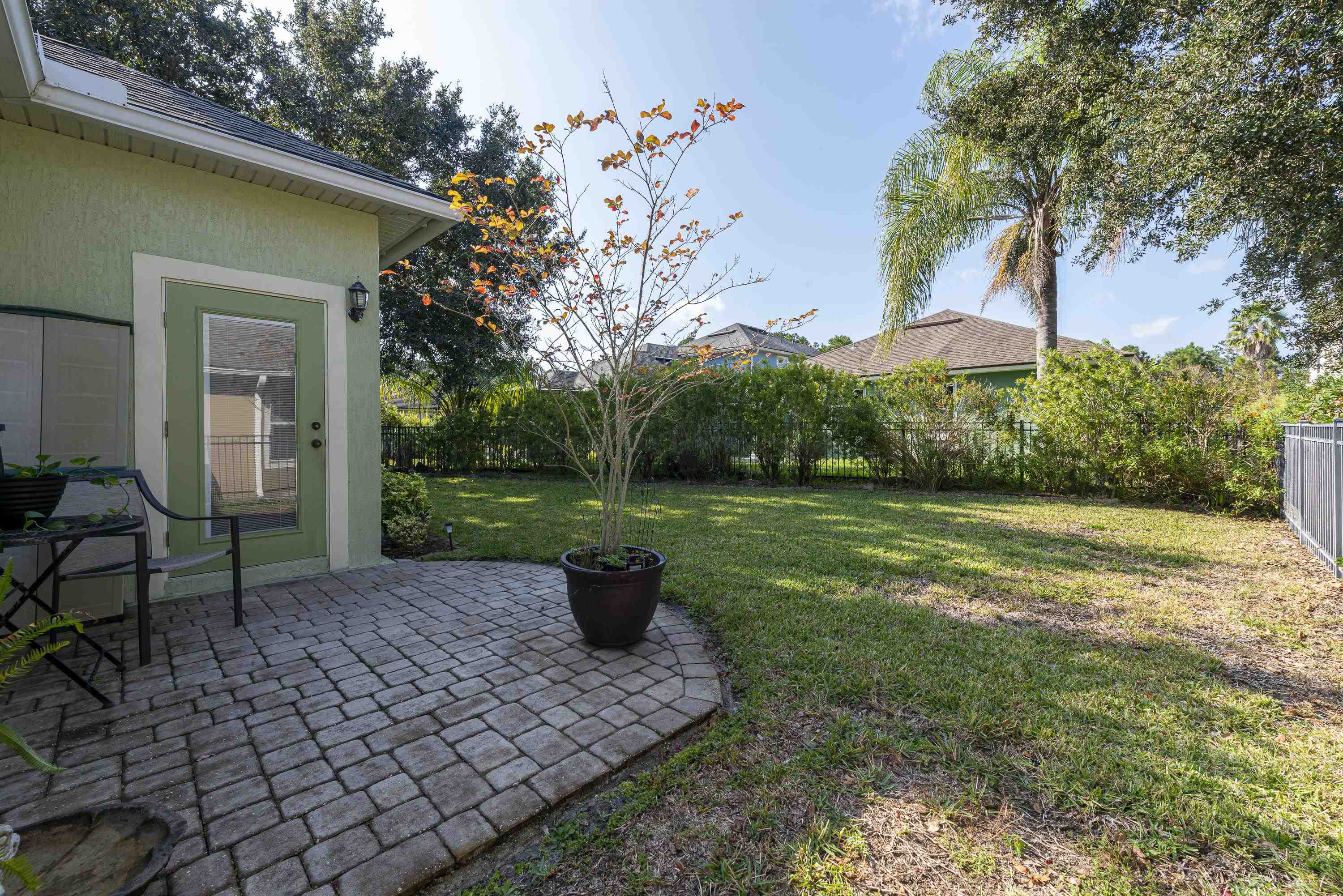 73 Durango Drive St. Augustine, FL 32086 - Photo 31 of 38 a view of a backyard with table and chairs potted plants and tree