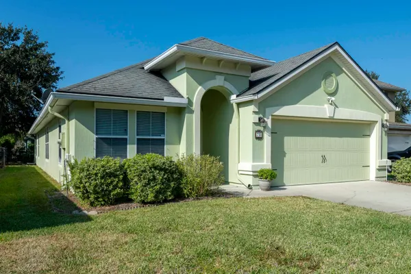 a front view of a house with lots of green space
