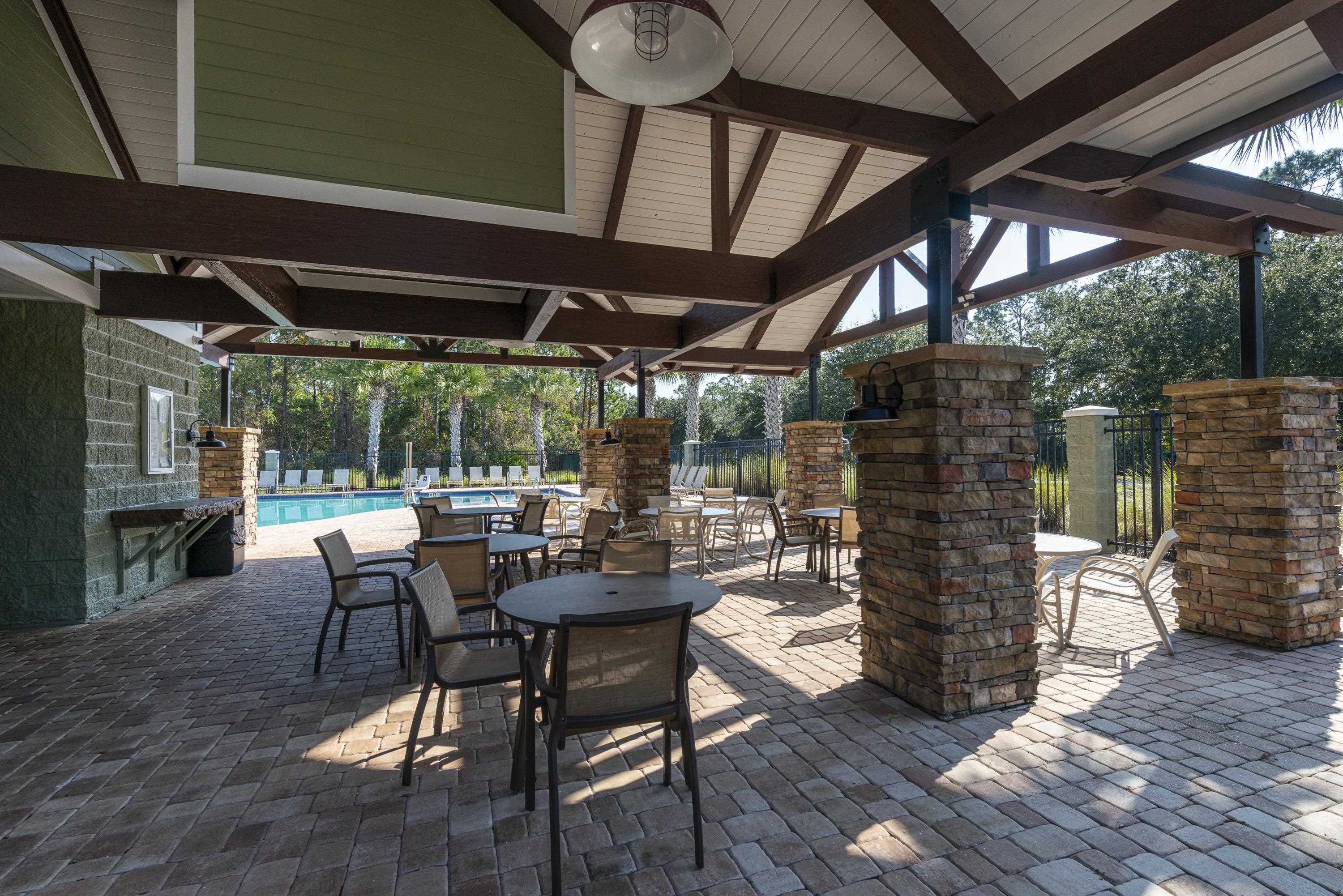 73 Durango Drive St. Augustine, FL 32086 - Photo 38 of 38 a view of a patio with table and chairs potted plants with wooden floor and fence