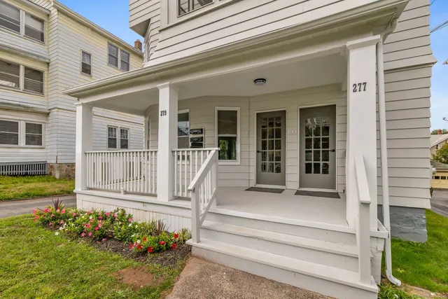 a front view of a house with a garden