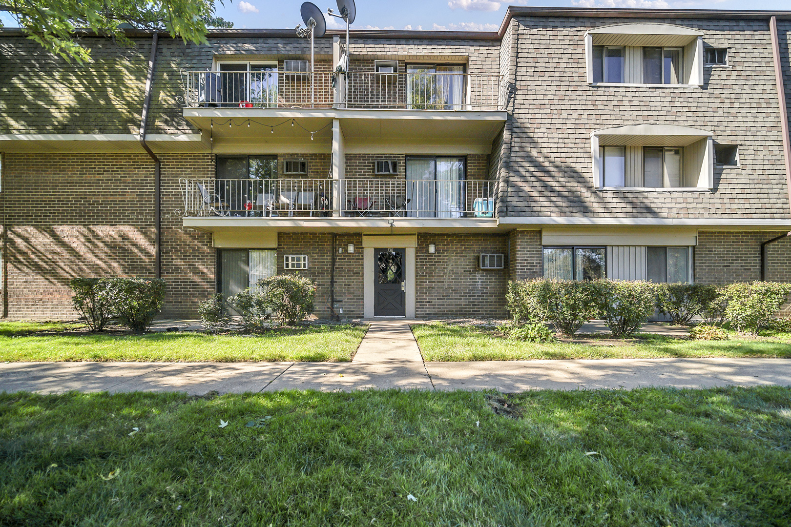 138 East Bailey Road, Unit M Naperville, IL 60565 - Photo 2 of 13 a front view of a house with a yard table and chairs