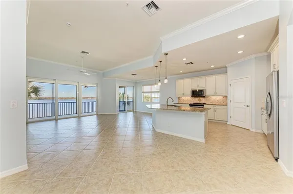 a kitchen with stainless steel appliances granite countertop a refrigerator a sink a stove and oven