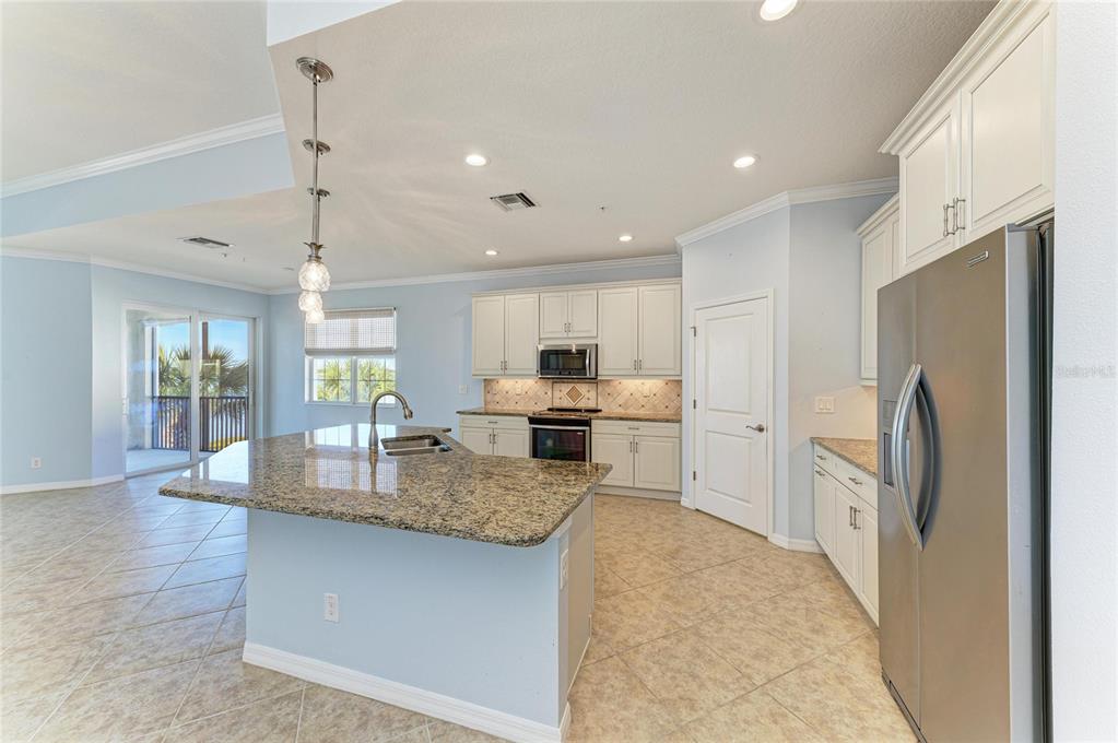 1246 Riverscape Street Bradenton, FL 34208 - Photo 12 of 68 a kitchen with stainless steel appliances granite countertop a refrigerator a sink a stove and oven