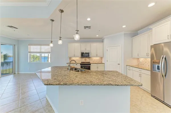a view of kitchen island a sink and a refrigerator