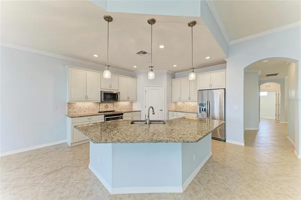 a kitchen with stainless steel appliances granite countertop a sink stove and refrigerator
