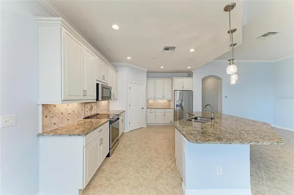 a kitchen with granite countertop white cabinets and a stove