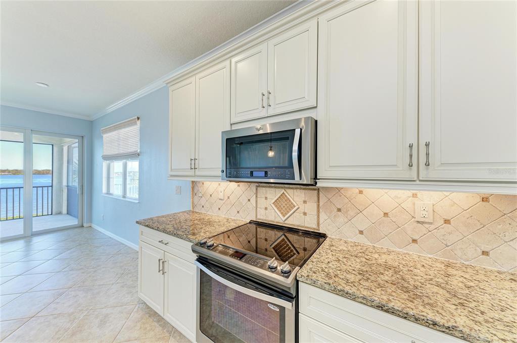 1246 Riverscape Street Bradenton, FL 34208 - Photo 17 of 68 a kitchen with granite countertop white cabinets and a stove