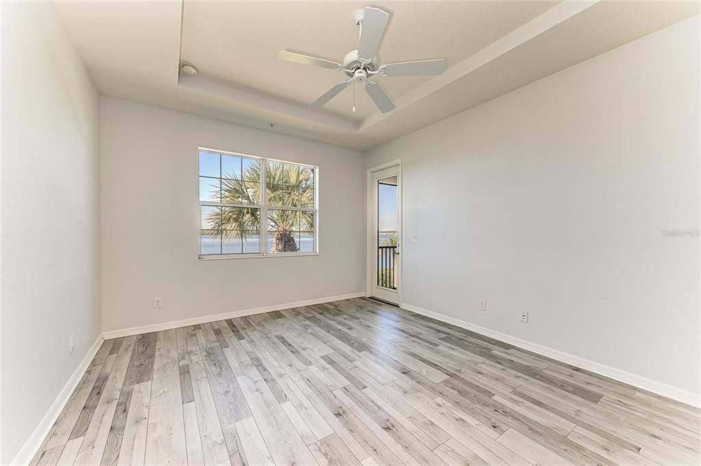 1246 Riverscape Street Bradenton, FL 34208 - Photo 31 of 68 an empty room with wooden floor chandelier fan and windows