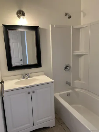 a bathroom with a tub sink and mirror