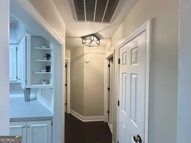 a view of a hallway with wooden floor