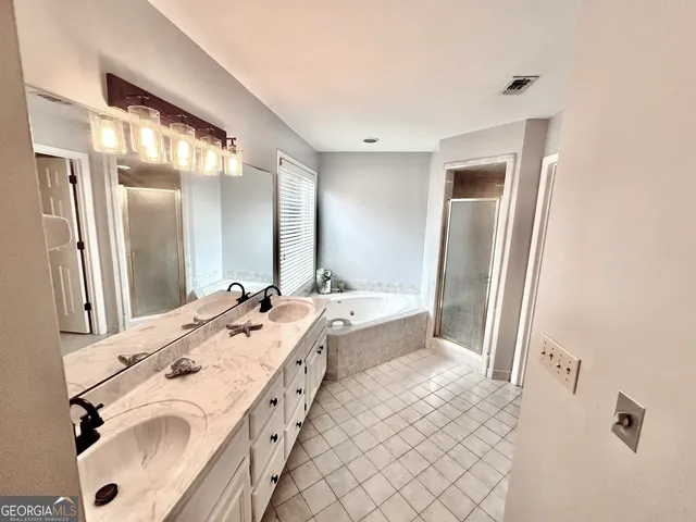 a bathroom with a double vanity sink mirror and shower