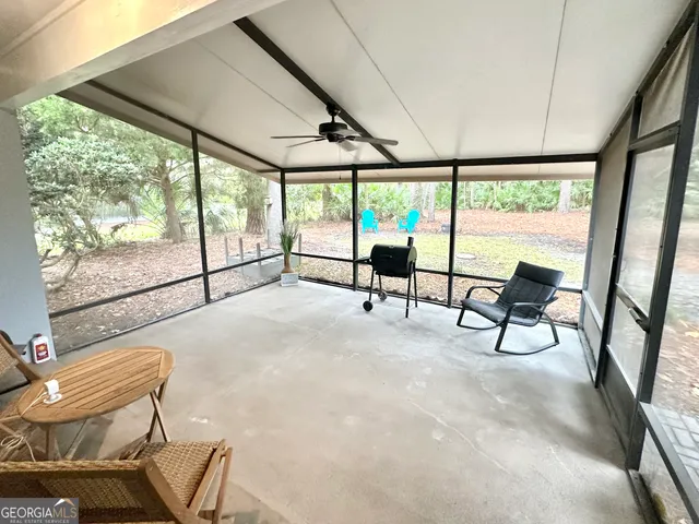 a view of backyard with a table and chairs and a large tree