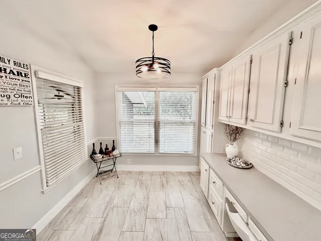 a kitchen with stainless steel appliances granite countertop a sink a stove a refrigerator a microwave oven with white cabinets and wooden floor