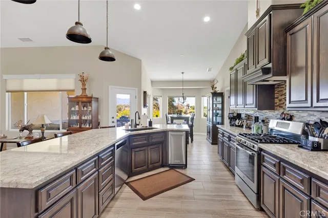 a kitchen with stainless steel appliances granite countertop a stove sink and cabinets