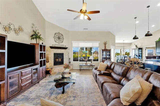 a living room with furniture kitchen view and a chandelier