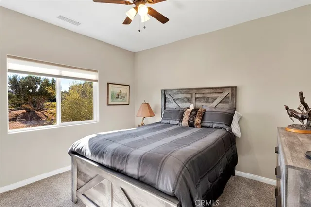 a view of a bedroom with wooden floor and windows