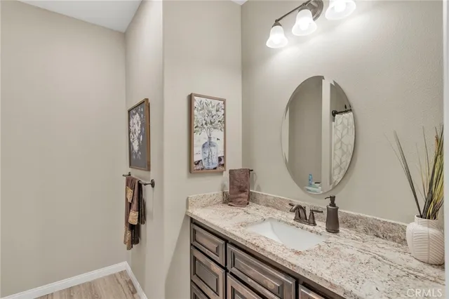 a bathroom with a granite countertop sink a toilet and a mirror