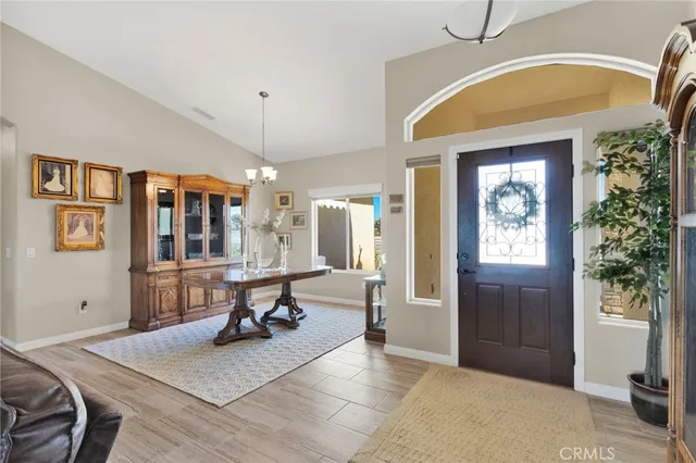 a kitchen with stainless steel appliances kitchen island granite countertop a table chairs and a refrigerator