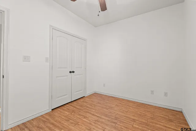 a view of an empty room with wooden floor