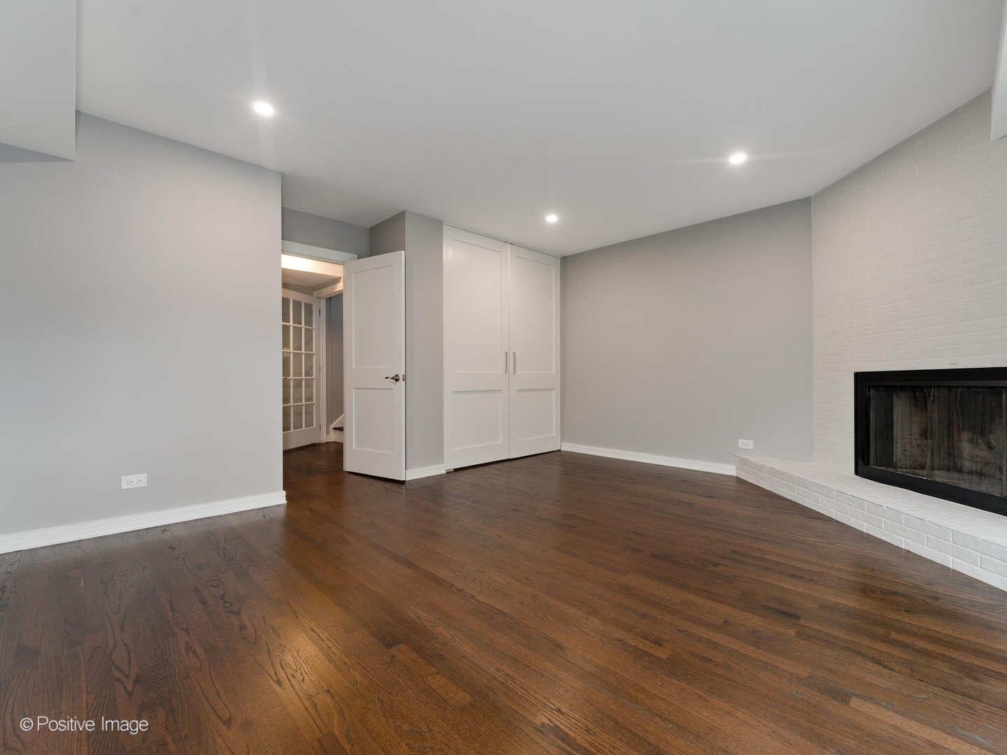 1114 West Altgeld Street, Unit A2 Chicago, IL 60614 - Photo 14 of 19 a view of an empty room with wooden floor and a fireplace