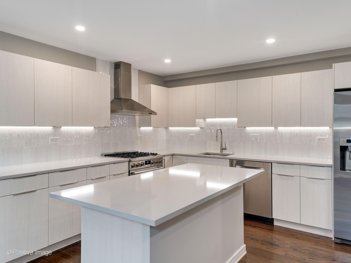 1114 West Altgeld Street, Unit A2 Chicago, IL 60614 - Photo 6 of 19 a kitchen with stainless steel appliances a sink a stove a microwave and wooden floor