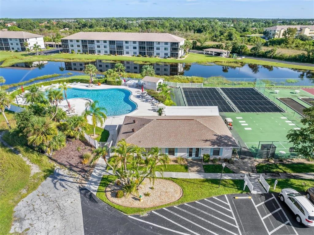an aerial view of a swimming pool with lawn chairs and large trees