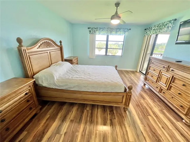 a bedroom with a bed wooden floor and window