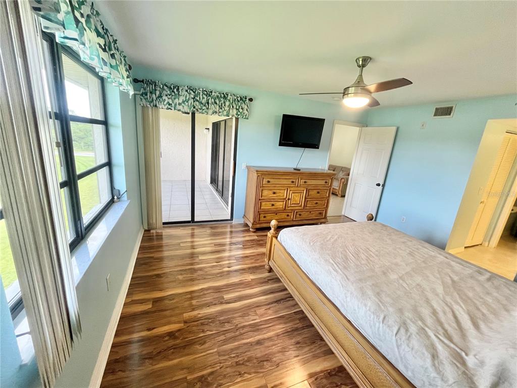 175 Kings Highway, Unit 236 Punta Gorda, FL 33983 - Photo 12 of 26 a bedroom with a bed wooden floor and a flat tv screen