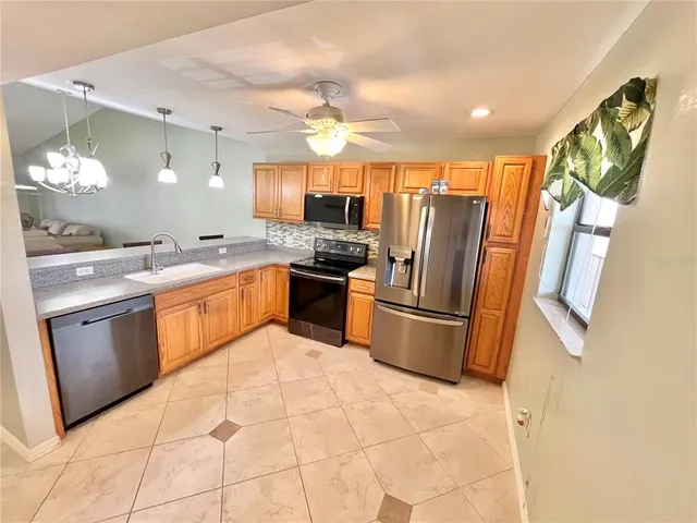 a kitchen with stainless steel appliances granite countertop a sink stove and refrigerator