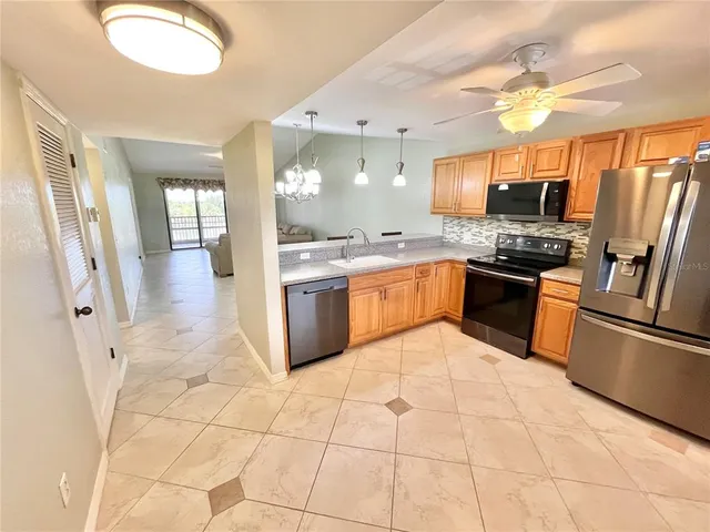 a large kitchen with cabinets and stainless steel appliances
