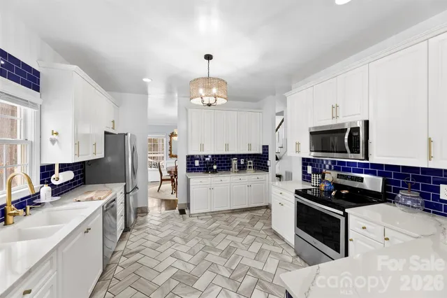 a kitchen with stainless steel appliances a stove top oven a sink a counter space and cabinets